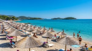 Na tym obrazie widać słoneczną, malowniczą plażę w Ksamiliu